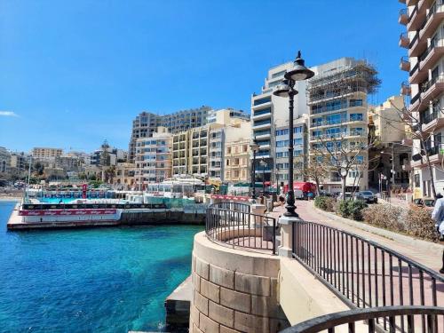 uitzicht op een rivier in een stad met gebouwen bij Malta Crown guesthouse in St Julian's