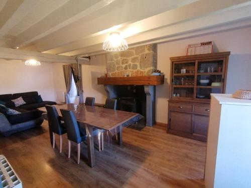 un salon avec une table et une cheminée dans l'établissement L'auvergnate, à Chambon-sur-Lac