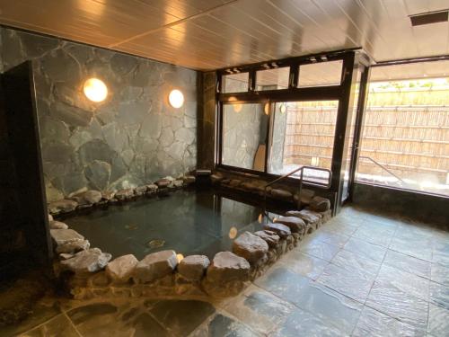 a pool of water in a room with rocks around it at Rangetsu in Kyoto