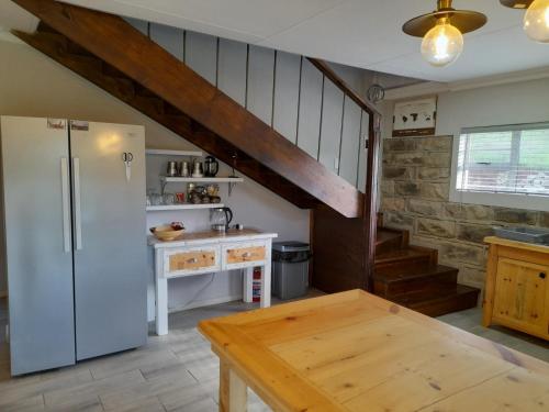 a kitchen with a refrigerator and a wooden table at Zamenkomst River Lodge in Maclear