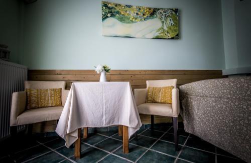 a table and two chairs with a white table cloth on it at Nymfes in Tsagarada