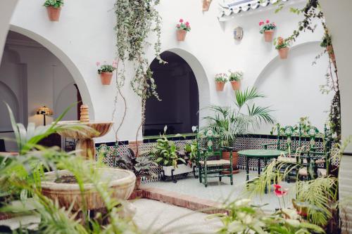 a courtyard with tables and chairs and plants at Hotel Villa Flamenca in Nerja