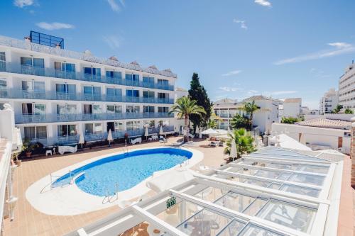 a view of a hotel with a swimming pool and a building at Villa Flamenca in Nerja