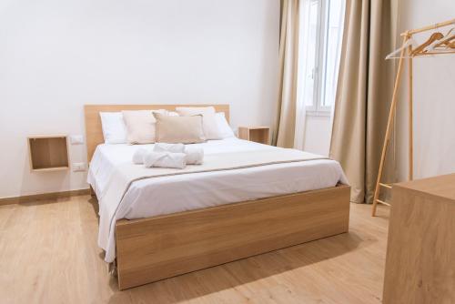 1 dormitorio con 1 cama grande con sábanas blancas en Cocci di tufo Appartamenti, en Rilievo