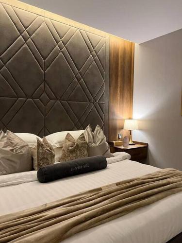uma cama num quarto de hotel com uma grande cabeceira em شاليه فيلا غرفتين نوم em ‘Anqāʼ