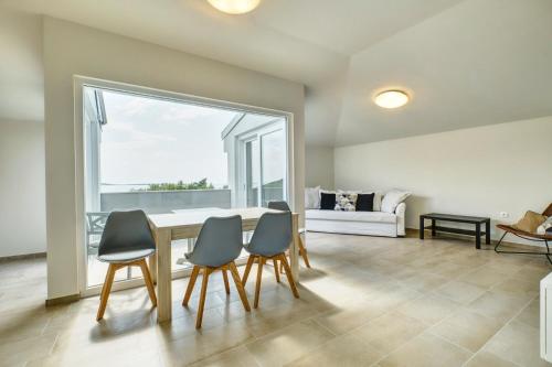 a dining room with a table and four chairs at Apartments Alberta in Miholašćica