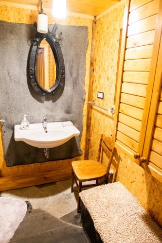 a bathroom with a sink and a table and a chair at Letnisko Sikory in Sikory