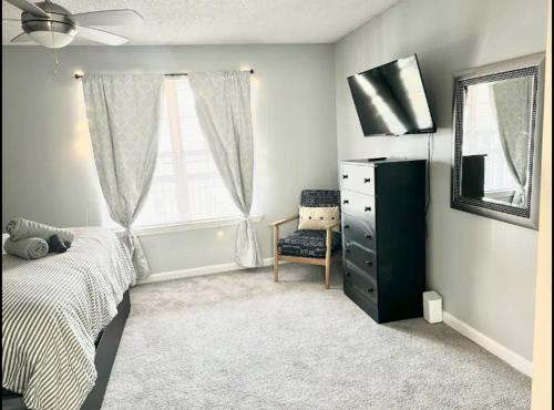 ein Schlafzimmer mit einem Bett, einer Kommode und einem Fenster in der Unterkunft King Suite - Private Bath - Home Theater Room 1 in Morrow