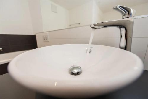 a white sink with water coming out of a faucet at Moderne Wohnung Jungtal in Grächen