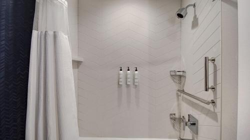 a bathroom with a shower with a white shower curtain at Fairfield by Marriott Inn & Suites Rochester Hills in Rochester Hills