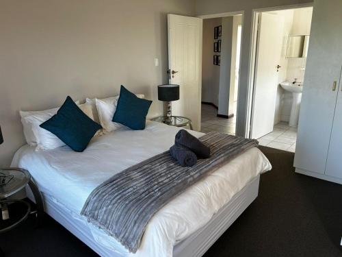 a bedroom with a large bed with blue pillows at Beacon Point in Mossel Bay