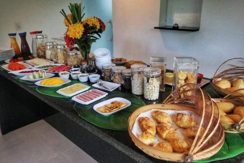 a buffet of food on a table with plates of food at Parada IT in Japaratinga