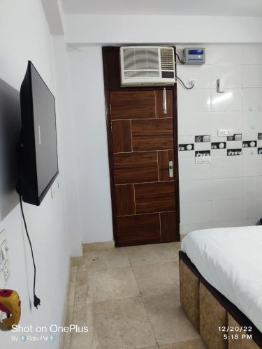 a small room with a television and a bed at Raj Residency Chhatarpur in New Delhi