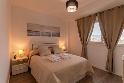 a bedroom with a bed with two towels on it at RentitSpain - Playa Granada - Apartamento Aguacate Golf y Costa in Motril
