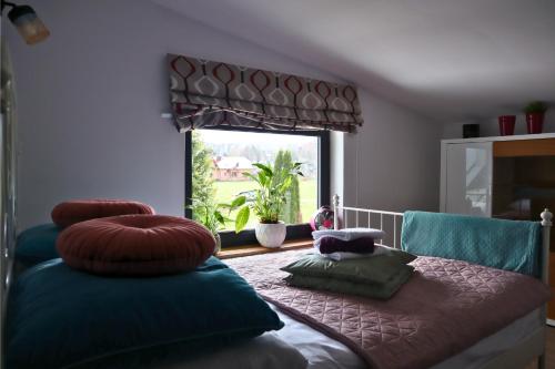 Zimmer mit einem Bett mit Kissen und einem Fenster in der Unterkunft Apartament Nawojowski in Nowy Sącz