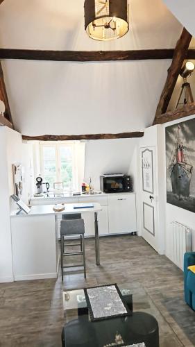 un salon avec une table et une cuisine dans l'établissement Logement entier Saint Malo vue mer, proche FERRY, commerces et plage Solidor 50 m, à Saint-Malo