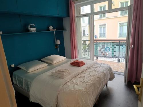 Un dormitorio azul con una cama con toallas. en Au logis Corneille, en Rouen