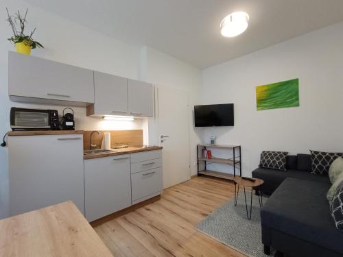 a kitchen and a living room with a couch at Ferienwohnung Gerlitzenblick in Villach