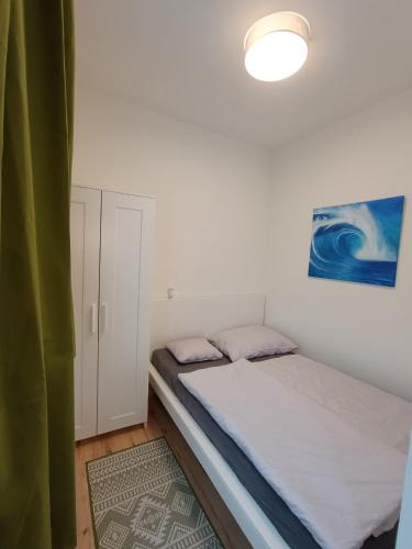 a small bedroom with a bed and a lamp at Ferienwohnung Gerlitzenblick in Villach