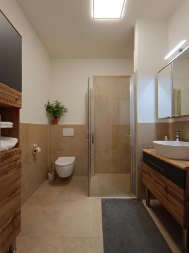 a bathroom with a shower and a toilet and a sink at Ferienwohnung Gerlitzenblick in Villach