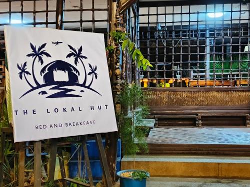 a sign for the local huts on a bench at Lokal Hut Bed and Breakfast in Puerto Princesa City