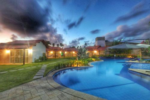 a house with a swimming pool at night at Parada IT in Japaratinga
