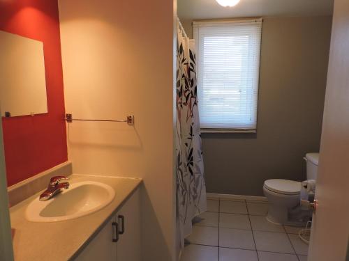 a bathroom with a sink and a toilet at Appartement touristique #5 Immeuble MH in LʼAnse-Saint-Jean