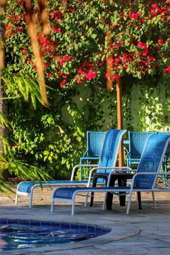 a group of blue chairs sitting next to a swimming pool at Parada IT in Japaratinga