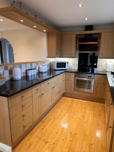 a large kitchen with wooden cabinets and black counter tops at Max's Woodland Lodge in Bridlington