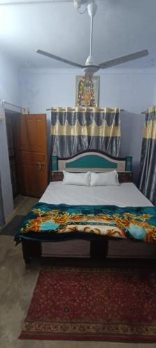 een slaapkamer met een bed en een plafondventilator bij Ratan home stay in Faizābād