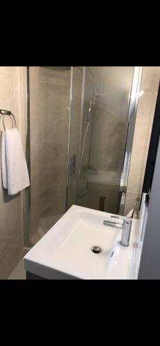 une salle de bain avec un lavabo blanc et une douche dans l'établissement Emplacement exceptionnel, à Antibes