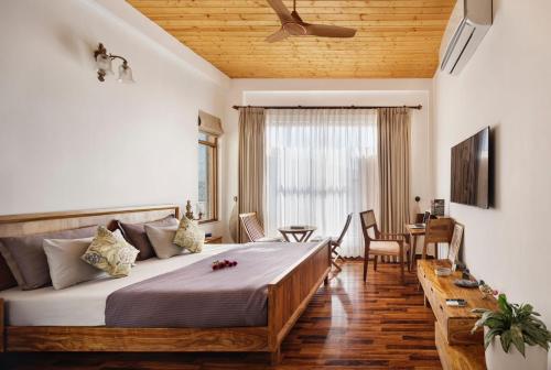 um quarto com uma cama grande e uma mesa em Charmed Chateau em Shimla