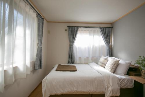 1 dormitorio con 1 cama blanca y ventana en Ikebukuro house with 5BR Free Parking, en Tokio