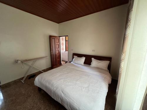 Rubavu的住宿－NINHO APPARTEMENT，一间卧室配有一张带白色床单的大床