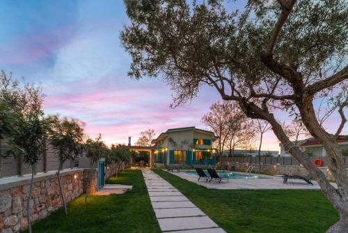 a backyard with a house and a tree at Serenity Villas in Kolimbia
