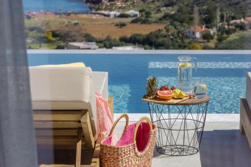 a table with a basket of fruit and a table with a tableasteryasteryastery at Sunny Drops Villas by Estia in Balíon