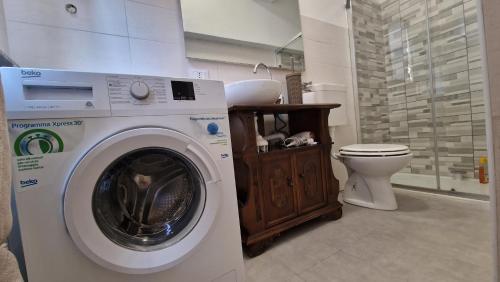 een wasmachine in een badkamer met een toilet bij Soleluna in Piacenza