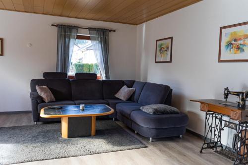 a living room with a couch and a table at Ferienwohnung Am Rhaunelbach in Rhaunen