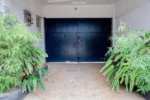 a large black garage door with plants in front of it at Shanny's apartment in Eldoret