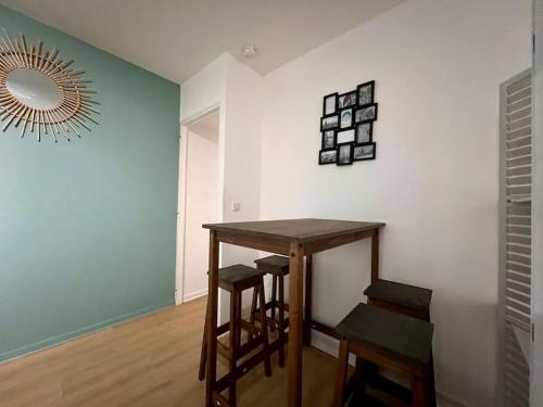 Cette chambre comprend une table, des tabourets et un miroir. dans l'établissement Appartement 4prsn / Au pied de la Citadelle, à Besançon