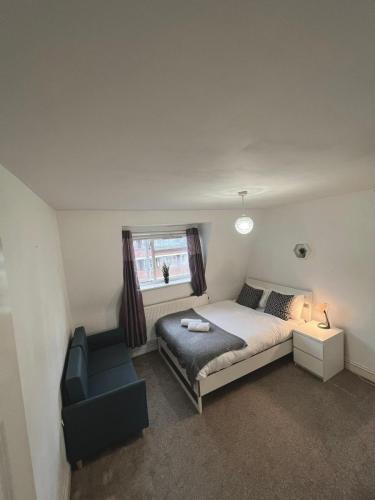 Cozy Room in whitechapel! Central London في لندن: غرفة نوم بسرير وكرسي ونافذة