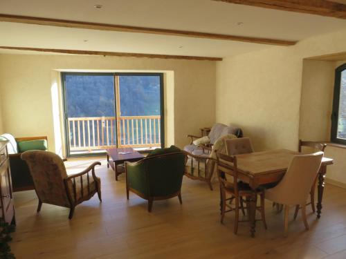 une salle à manger avec une table et des chaises et une grande fenêtre dans l'établissement Grande maison de village, rénovation écologique, à Viey