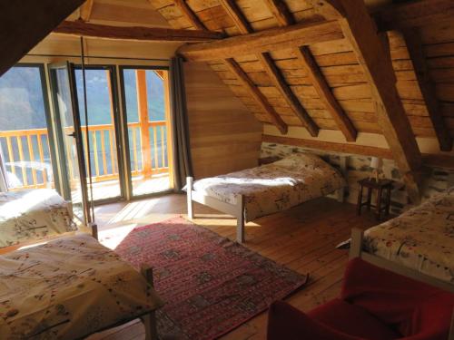 une chambre avec deux lits dans une pièce avec fenêtres dans l'établissement Grande maison de village, rénovation écologique, à Viey