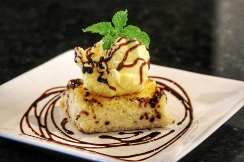 a piece of cake with ice cream and a mint on a plate at Parada IT in Japaratinga