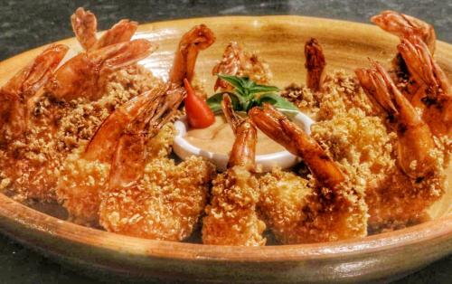 a plate of food with shrimp and dipping sauce at Parada IT in Japaratinga