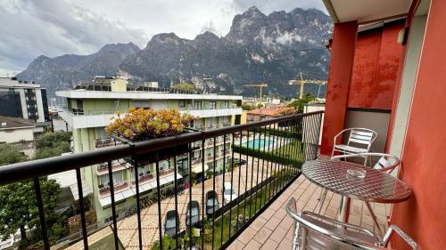 a balcony with a table and chairs and mountains at Hotel Royal in Riva del Garda
