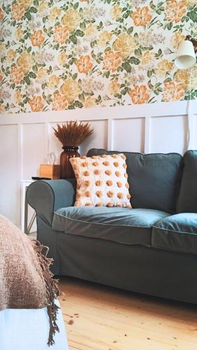 a blue couch in a living room with a floral wallpaper at Sebuzínka in Ústí nad Labem
