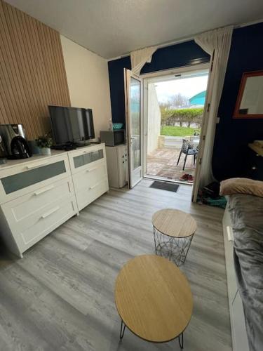 un salon avec une télévision, une table et des chaises dans l'établissement L'écume de Pentrez, à Saint-Nic