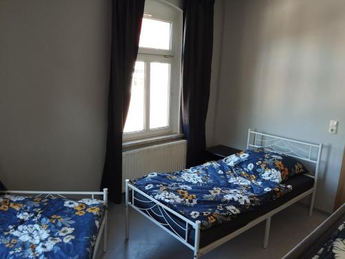 a bedroom with two beds and a window at Stadtblick 2 Monteuerglück in Eisenberg