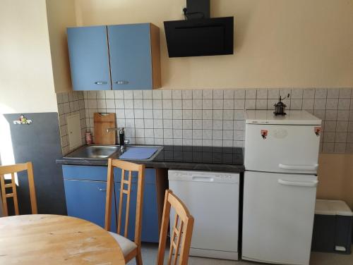 a kitchen with blue cabinets and a white refrigerator at Stadtblick 2 Monteuerglück in Eisenberg